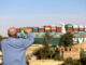 A spectator waves as the Ever Given container ship moves along the Suez Canal towards Ismailia after being freed -energynewsbeat.com