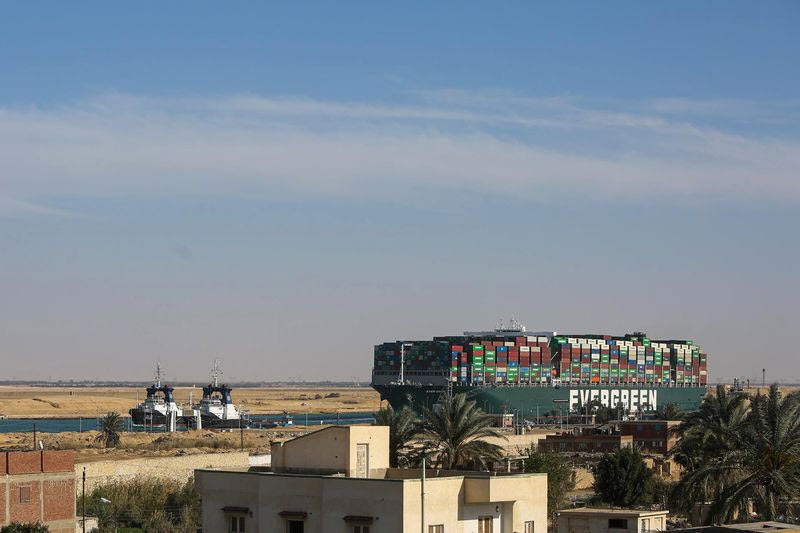 Tug boats pull the Ever Given container ship along the Suez Canal - energy News Beat