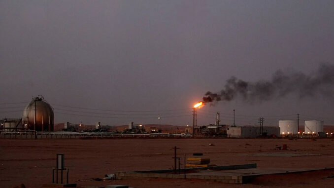 A flame from a Saudi Aramco oil installation known as “Pump 3” burns brightly during sunset in the desert near the oil-rich area Al-Khurais.