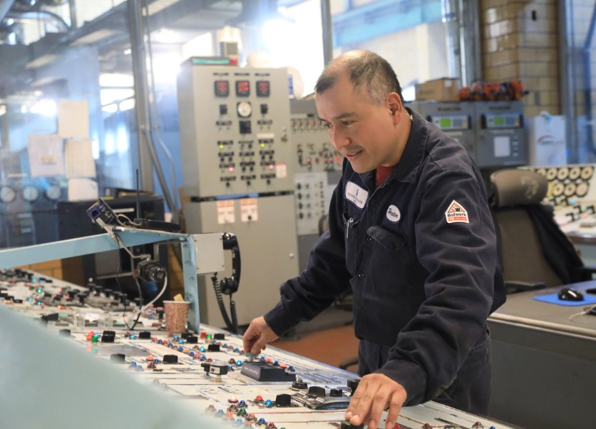 First class control operator Hector Martinez at the control panel for a turbine inside the Danskammer power plant on December 9, 2022. The plant uses natural gas to produce steam which spins the turbines and creates electricity.