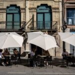 Customers shelter from the sun at a cafe in Lleida, Spain.Photographer: Angel Garcia/Bloomberg