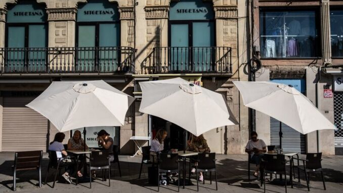 Customers shelter from the sun at a cafe in Lleida, Spain.Photographer: Angel Garcia/Bloomberg