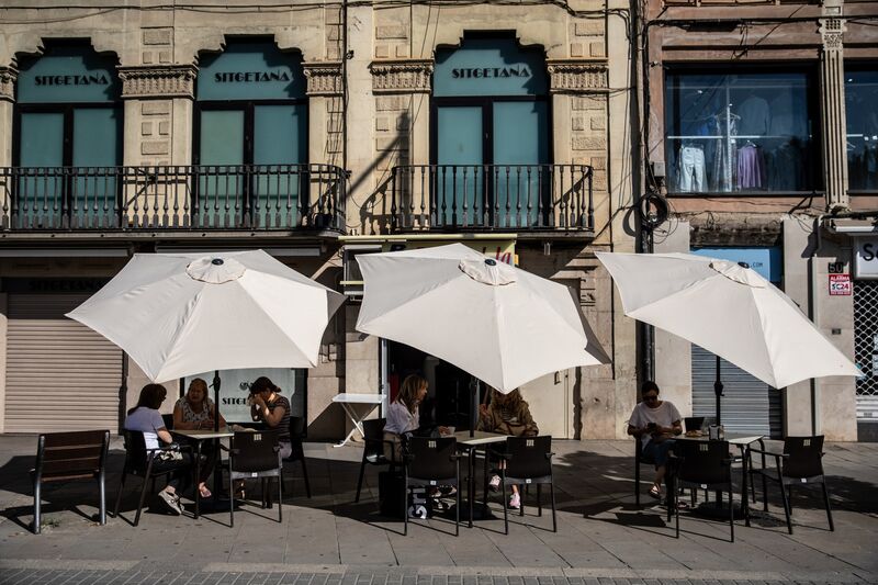 Customers shelter from the sun at a cafe in Lleida, Spain.Photographer: Angel Garcia/Bloomberg